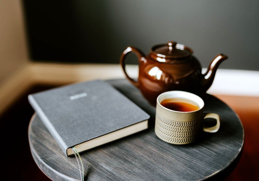 A teapot, a mug of tea and a notebook on a side table in the coaching room