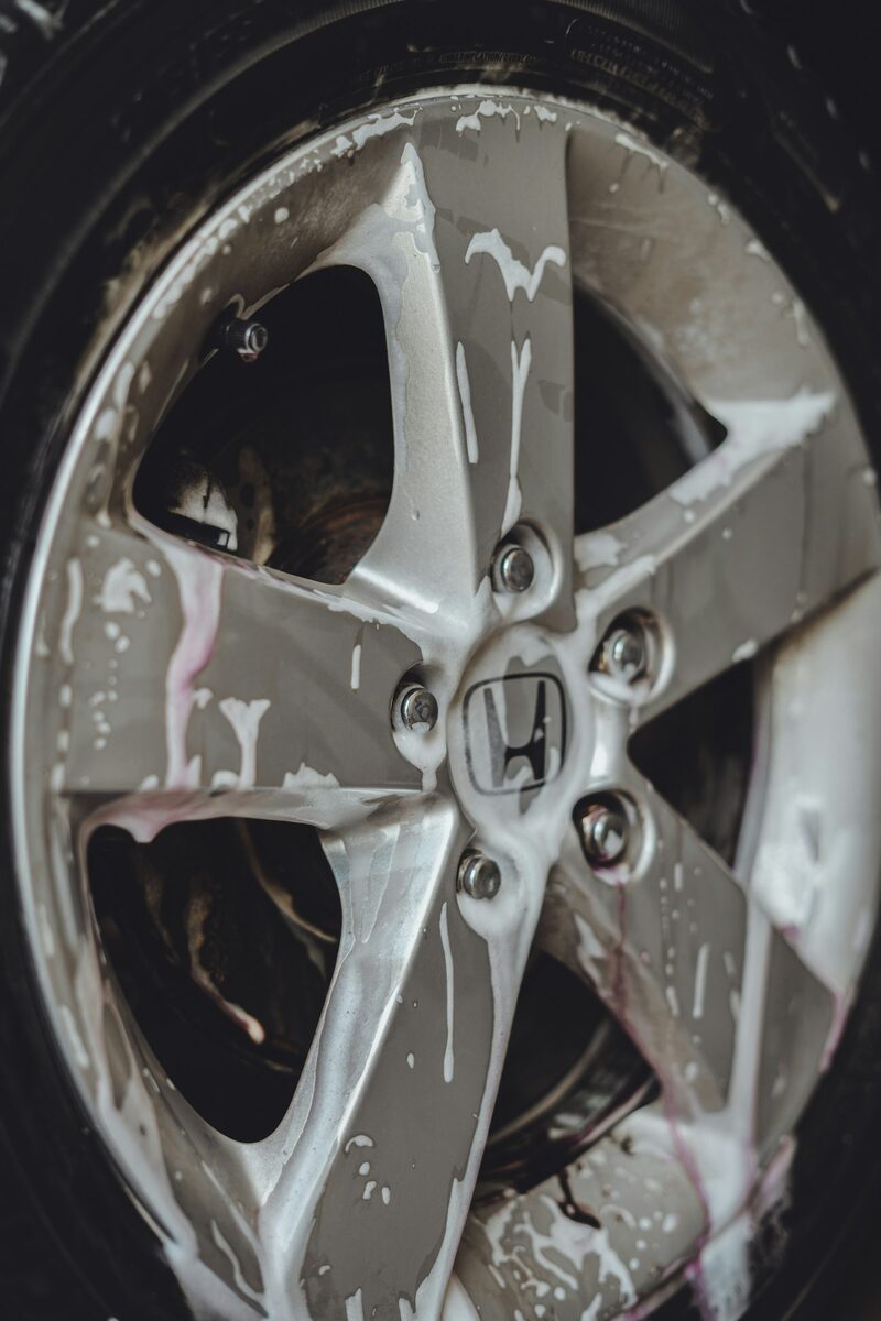 An alloy wheel covered in cleaning foam